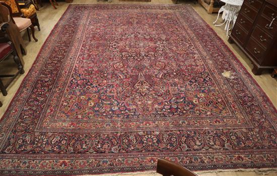 A Tabriz carpet with foliate pattern on a wine field (worn) approx. 480 x 340cm (holed)